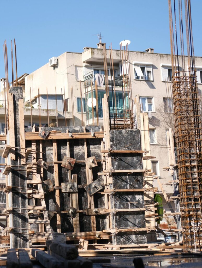 Concrete and steel construction site in İzmir, Türkiye with workers.